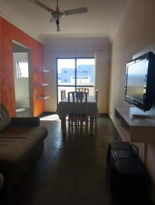 ein Wohnzimmer mit einem Sofa, einem Tisch und einem TV in der Unterkunft praia grande sp in Praia Grande