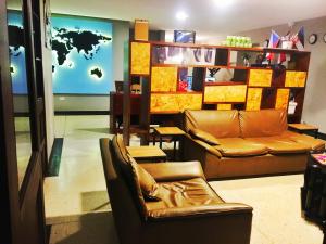 Les Balcons Hostel في بوبايان: غرفة بها كرسيين جلديين وأريكة