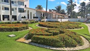 a garden in front of a building with a hedge at Apartamentos Beira Mar Marinas Tamandare PRAIA DOS CARNEIROS in Praia dos Carneiros