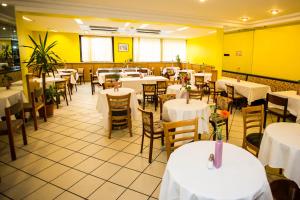 a restaurant with white tables and chairs and yellow walls at Hotel Geblergasse in Vienna