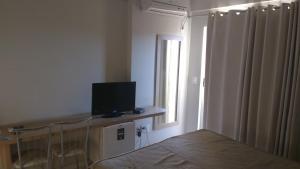 a bedroom with a bed and a television and a window at Golden Dolphin Express Roberto imoveis in Caldas Novas