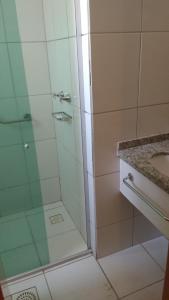 a bathroom with a glass shower with a sink at Golden Dolphin Express Roberto imoveis in Caldas Novas