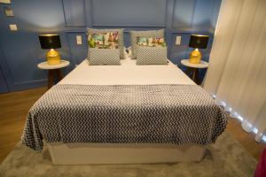a bedroom with a bed with a black and white blanket at ZIGZAG HOSTEL in Praia da Vitória