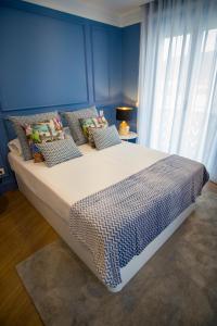 a bedroom with a large bed with a blue wall at ZIGZAG HOSTEL in Praia da Vitória