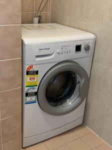 a white washing machine in a corner of a room at Lemontree Cottage in Kingscote