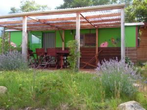 una casa verde con mesa y sillas en un campo en Le Gît´an Roulotte, en Bessey