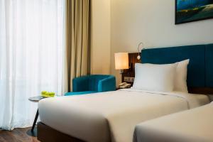 A bed or beds in a room at Maximilan Danang Beach Hotel