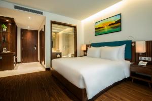 A bed or beds in a room at Maximilan Danang Beach Hotel