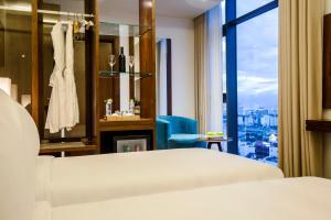 A bed or beds in a room at Maximilan Danang Beach Hotel