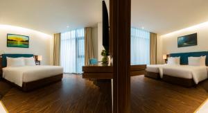 A bed or beds in a room at Maximilan Danang Beach Hotel