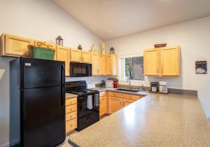 a kitchen with a black refrigerator and wooden cabinets at Pinetop Paradise in Pinetop-Lakeside