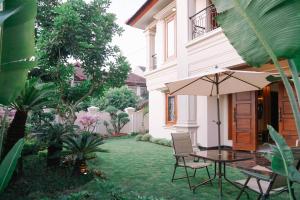 a patio with an umbrella and a table and chairs at Fernasya House in Yogyakarta