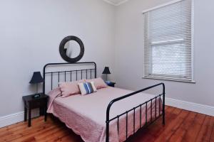 a bedroom with a bed and a mirror on the wall at Maeville Cottage in Broken Hill