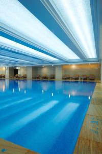 a large swimming pool in a hotel with blue ceilings at Novotel Guiyang Panjiang in Guiyang