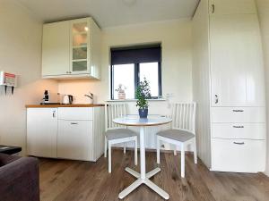 a small kitchen with a table and two chairs at Austurey Cottages in Laugarvatn