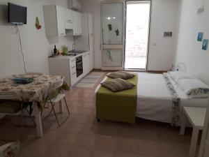 1 dormitorio con cama, mesa y cocina en Monolocale Santa Caterina, en Santa Caterina di Nardò