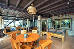 a dining room with a wooden table and benches at Huan Kawin Est.58 Lanna Home & Collection in Chiang Rai