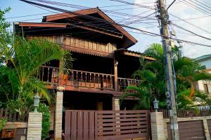 une maison avec une clôture en bois devant elle dans l'établissement Huan Kawin Est.58 Lanna Home & Collection, à Chiang Rai