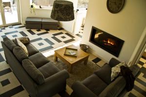 sala de estar con sofá y chimenea en Villa des Groseilliers Spa Practice golf moutons, en Loison-sur-Créquoise