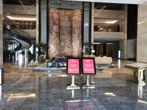 a lobby with two signs in the middle of a building at Ramada Wyndham Zhengzhou Xinzheng in Xinzheng