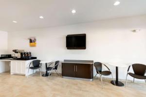 a room with tables and chairs and a tv on the wall at Motel 6-Channelview, TX in Channelview