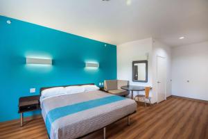 a bedroom with a bed and a blue wall at Motel 6-Channelview, TX in Channelview