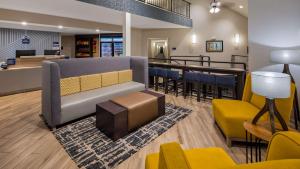une salle d'attente avec un canapé, des chaises et un bar dans l'établissement Best Western Hampshire Inn & Suites, à Seabrook