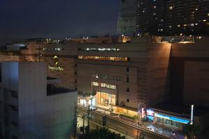 een nachtzicht op een groot gebouw met een straat bij MANDALUYONG 2 Br w 2 Queen, 50HDtv across Shangrila Mall in Manilla