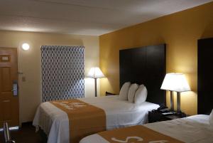 里奇蘭的住宿－Days Inn by Wyndham Ridgeland South Carolina，酒店客房设有两张床和两盏灯。