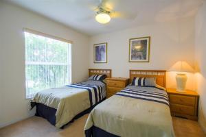 two beds in a room with a window at Luxury 4BR Pool Home with Jacuzzi- Inverness in Inverness +10 photos