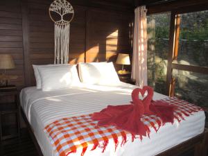 A bed or beds in a room at Twin Island Villas & Dive Resort