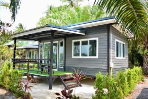 a small tiny house with a green porch at Baantia Chomtawan in Suratthani