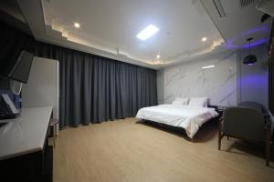 釜山的住宿－Bestie Hotel，配有一张床和一张书桌的酒店客房