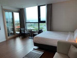 a hotel room with a bed and a table at Lemain Hotel in Jeju