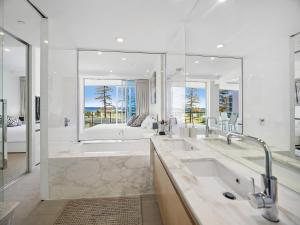 a bathroom with a large tub and a large mirror at Nirvana By The Sea in Gold Coast