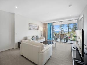 a living room with a white couch and a television at Nirvana By The Sea in Gold Coast