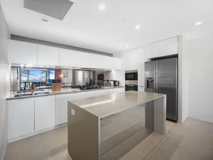 uma cozinha com armários brancos e um balcão branco em Nirvana By The Sea em Gold Coast