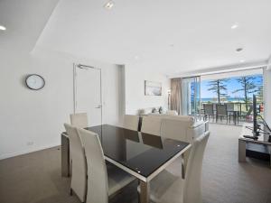 
a living room with a table and chairs at Nirvana By The Sea in Gold Coast
