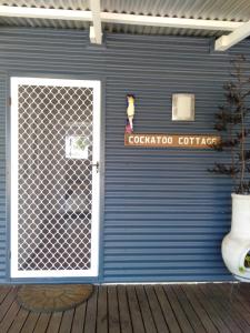 un edificio azul con una puerta y una señal en él en Redtail Ridge Cottages, en Hester