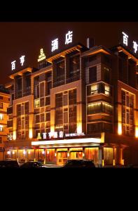 Un gran edificio con luces en la parte superior por la noche. en Yiwu Bai Heng Hotel, en Yiwu