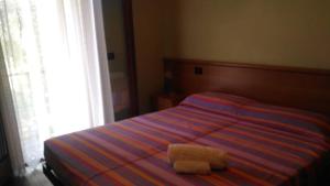Un dormitorio con una cama con una toalla. en agriturismo AI COLORI, en Paese