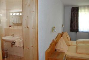 a bathroom with a sink and a bed in a room at Landgasthof im Ehegrund in Sugenheim