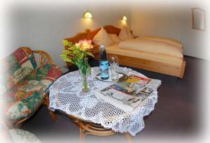una camera con tavolo e letto e un tavolo con un vaso con di Landgasthof im Ehegrund a Sugenheim