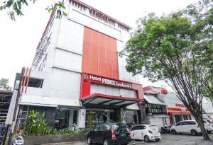 a building with cars parked in front of it at OYO 1318 Hotel Prince Boulevard in Manado