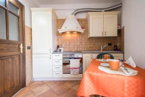 una cucina con tavolo e tovaglia arancione di Casa Lucia a Castelbuono