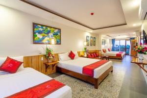 a hotel room with two beds and a couch at Villa Loan A HOI AN in Hoi An