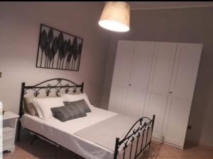a bedroom with a bed with white sheets and a lamp at Clasa vacanza in Martina Franca
