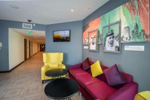 a living room with a red couch and a yellow chair at Premier Inn Dubai Silicon Oasis in Dubai