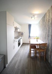 a kitchen and dining room with a table and chairs at Ferienhof-Friedenshof-Gerste in Vollerwiek