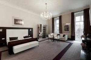 sypialnia z łóżkiem i żyrandolem w obiekcie Old Town Square Residence by Emblem w Pradze